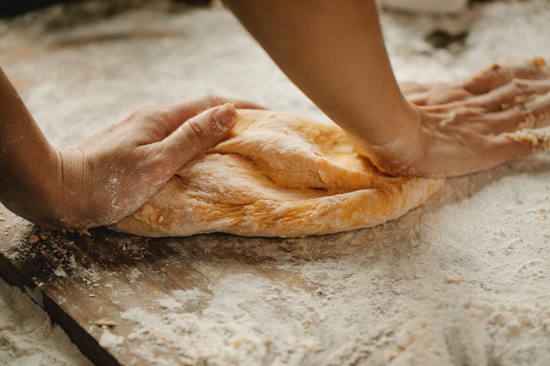 2 bàn tay đang nhồi bột mì